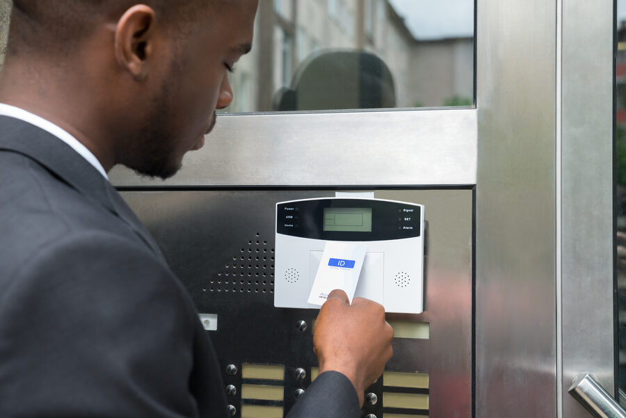 Someone using a keyless entry card to gain access into an office building.