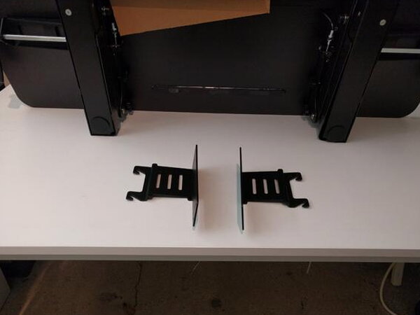 A Phillips screwdriver and screws used to fasten the FlexiSpot keyboard platform brackets