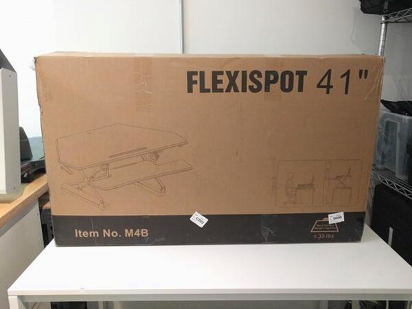 The large FlexiSpot 41 inch retail box sitting on a desk