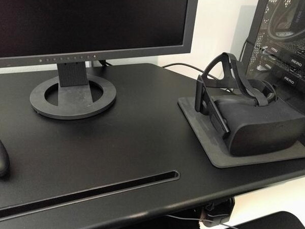 A monitor and Oculus VR headset sitting on the raised FlexiSpot desk surface