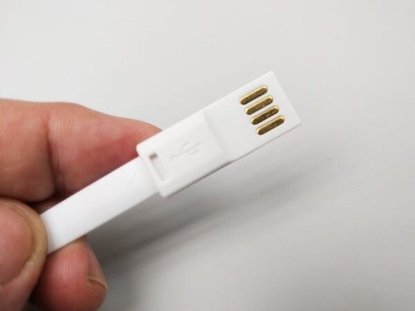 A hand holding the Luminoodle's reversible USB plug