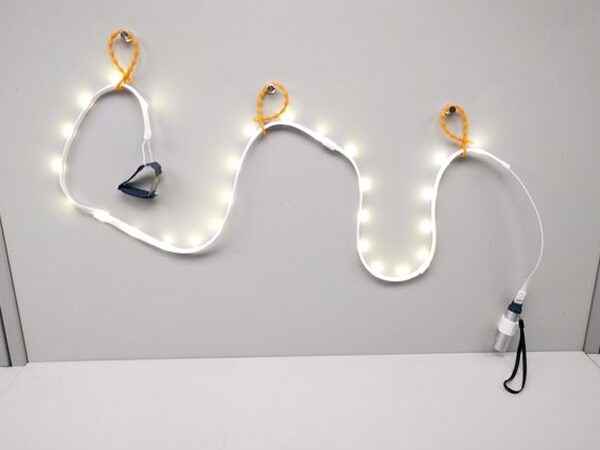 The Luminoodle light rope lit up and mounted with its ties on a tabletop