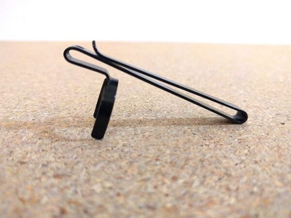 The two-way pocket clip removed from the Olight H2R Nova, standing on its own