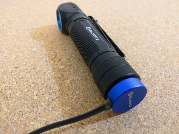 The magnetic charging cable snapped onto the Olight H2R Nova tailcap