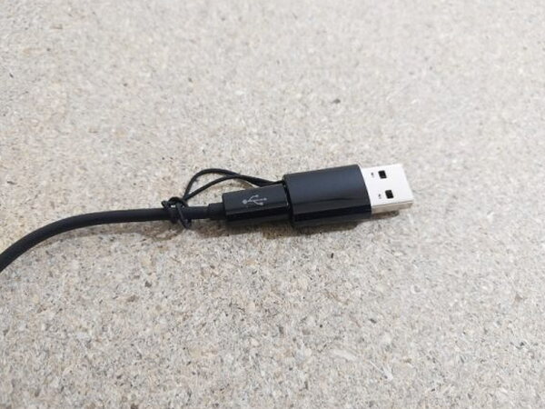 The FIIL CANVIIS Pro charging cable coiled with its USB-A adapter clicked into place