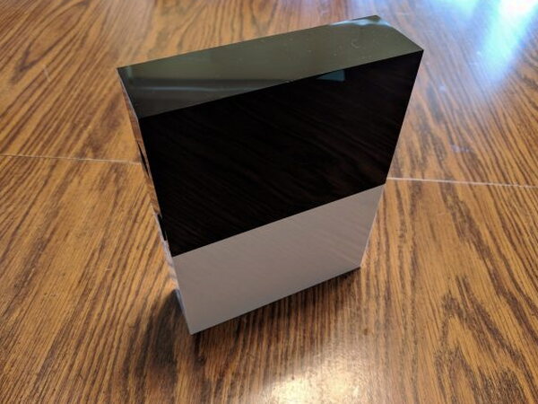Abode Gateway standing upright on a wood table