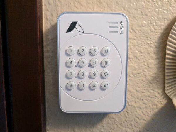 Abode Wireless Keypad mounted next to a doorway