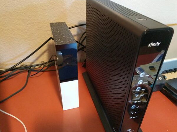 Abode Gateway connected beside a router with cables attached