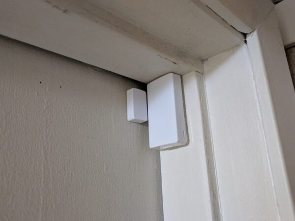 Abode Mini Door Sensor mounted on a white door frame