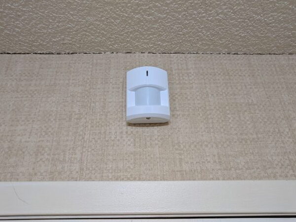Abode Motion Sensor mounted high on a wall near the ceiling