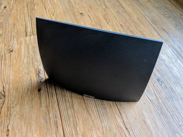 Curved black Mohu AirWave Basic indoor antenna standing on the floor