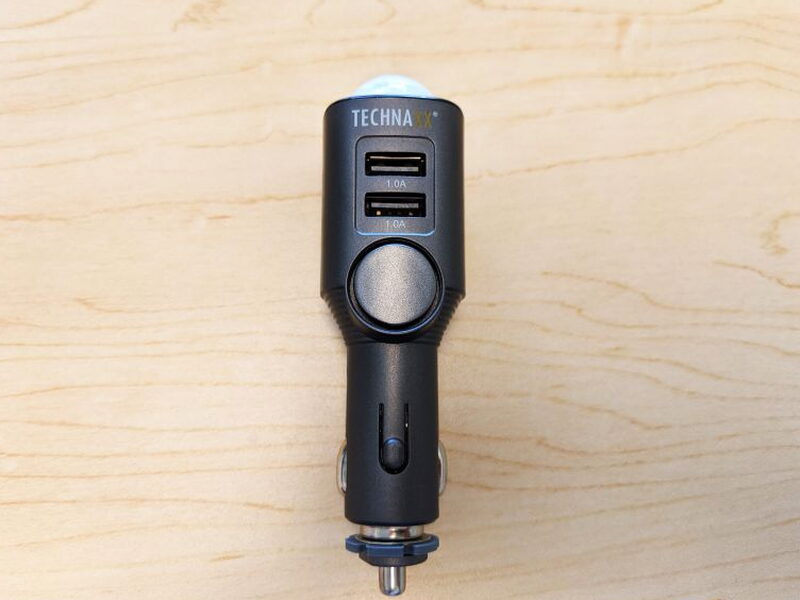 The front of the TX-100 shows the two USB ports, main button area, and charger plug.