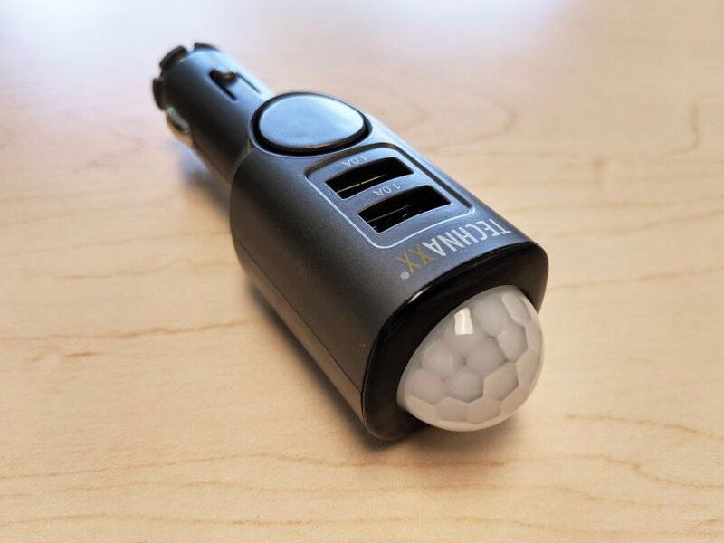 The white PIR motion sensor dome sits on the end of the charger-style body.