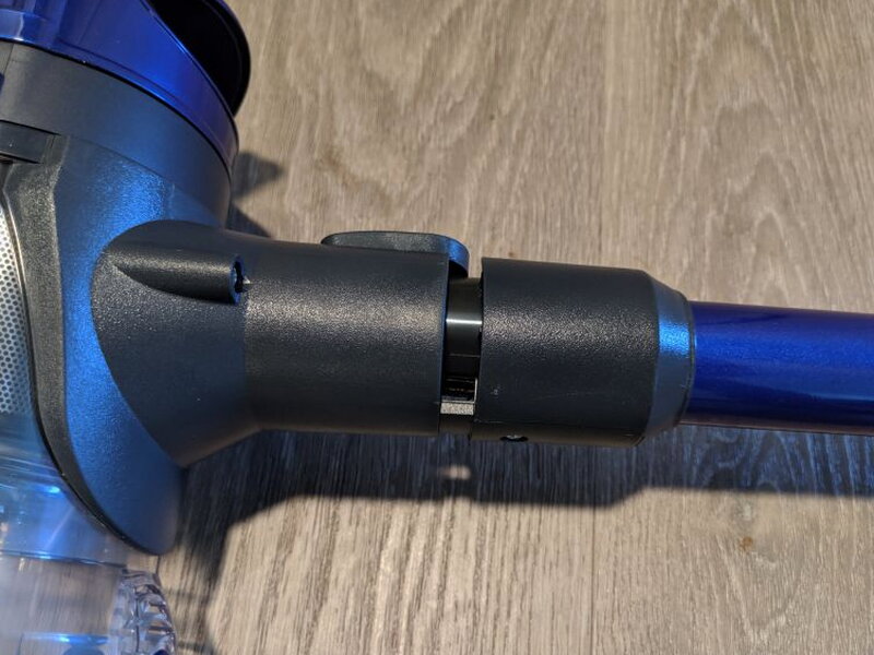 The attachment joint locks onto the front of the vacuum with a plug and latch.