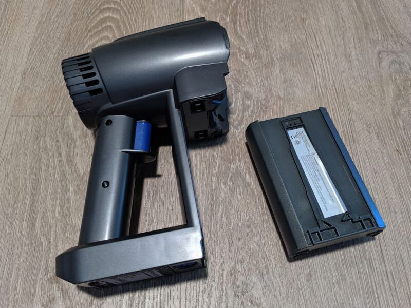 The removable battery slides away from the handheld motor assembly.