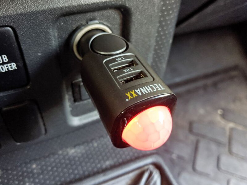 A close view of the installed TX-100 with the PIR sensor glowing red.