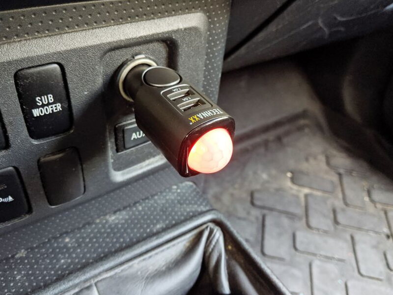 The TX-100 glows red while charging from the vehicle cigarette lighter socket.