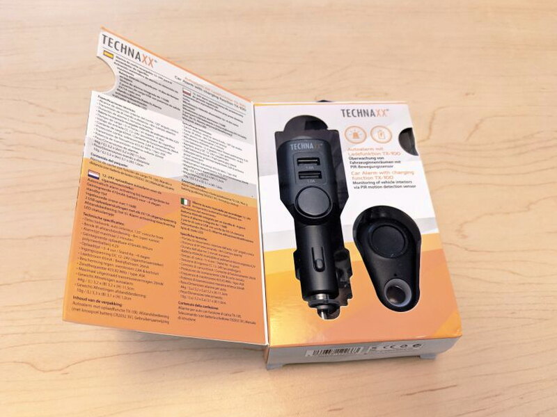 The box opens to show the TX-100 and remote through a cutaway beside multilingual specifications.