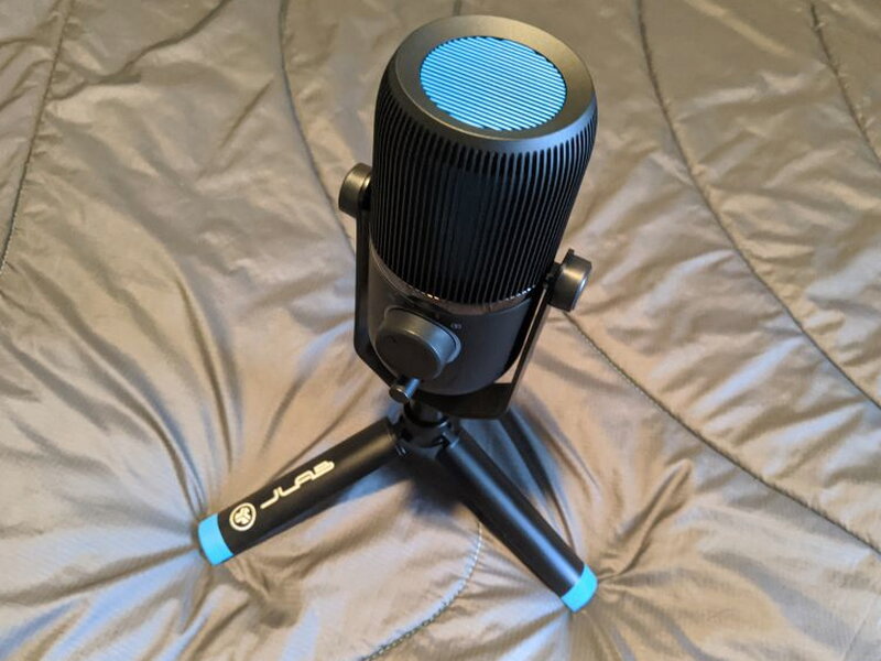 The Talk on its folding tripod, blue accents on both the grille and the tripod feet.