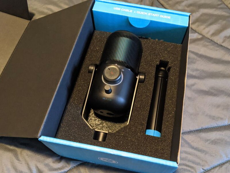 The box open, mic and folded tripod nested in molded foam.