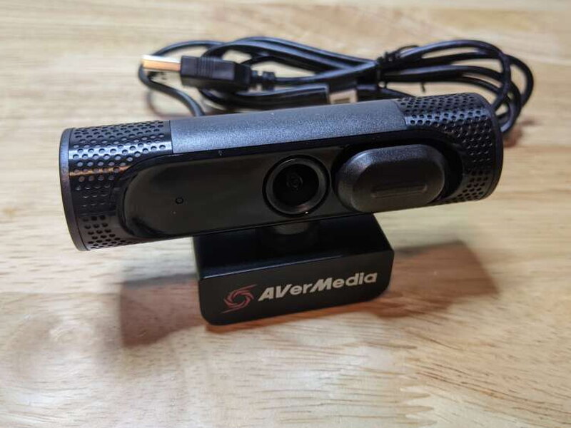 The front of the webcam shows the lens, privacy slider, microphone openings, and AVerMedia logo.