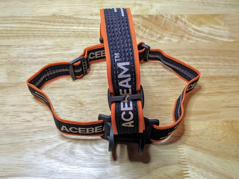 The headband has adjustable straps and prominent Acebeam branding.