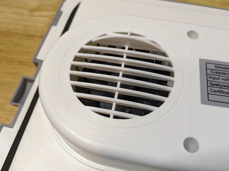 Round fan vent and rating label on the underside of the lid.