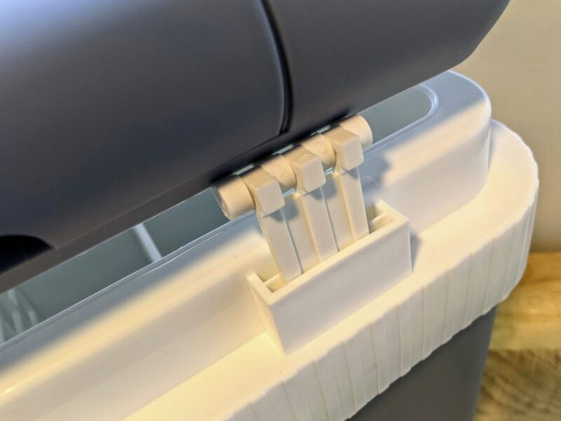 Hinge tabs pressed into place during lid installation.
