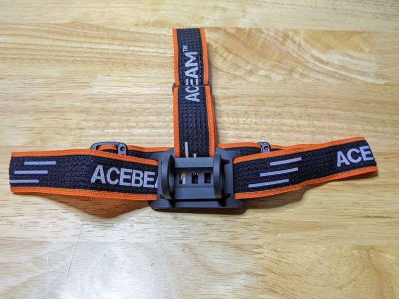 The included Acebeam headband laid flat with the front mount visible.