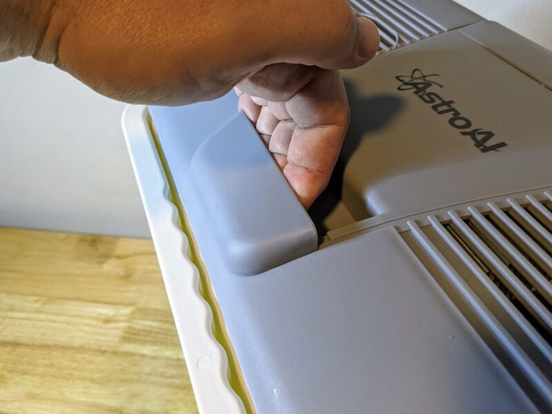 Pulling up the lid handle to open the cooler.