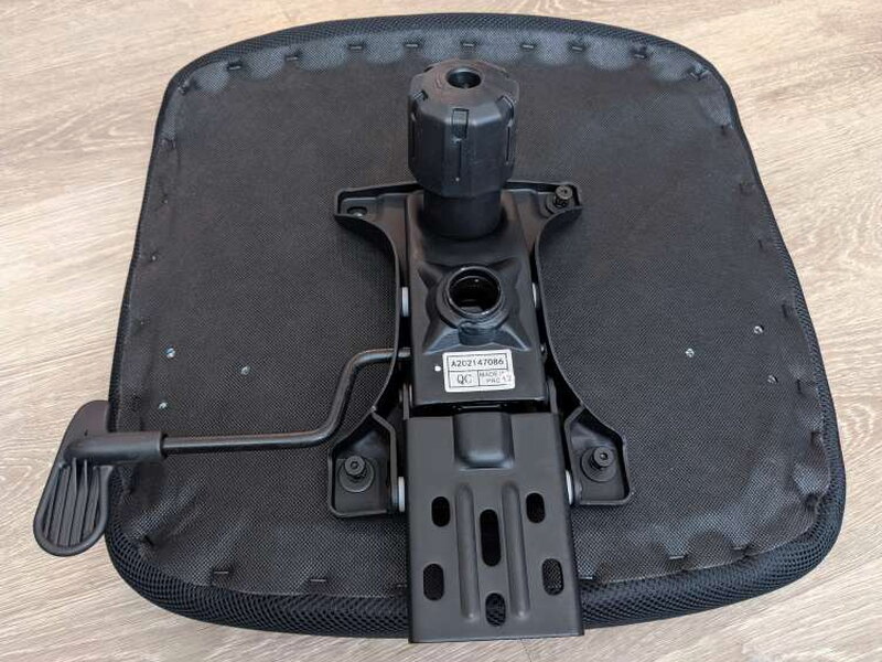 The seat cushion flipped over, mechanism already attached underneath.
