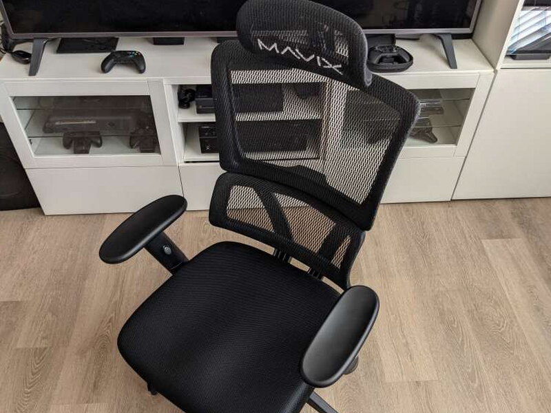 The mesh backrest is open enough that you can see straight through it to the TV cabinet behind.