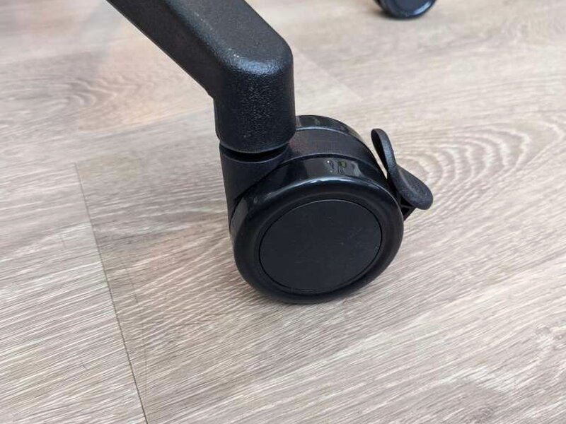 One of the five locking casters, lever visible on the side.