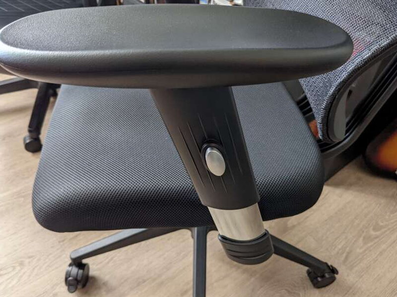 The armrest post and its height-adjustment button.