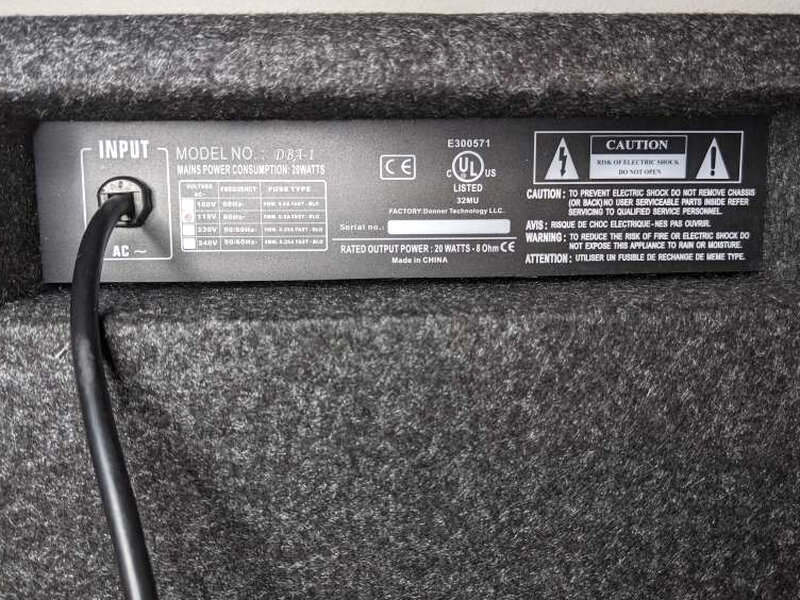 The rear panel shows the attached power cord and printed amplifier information.