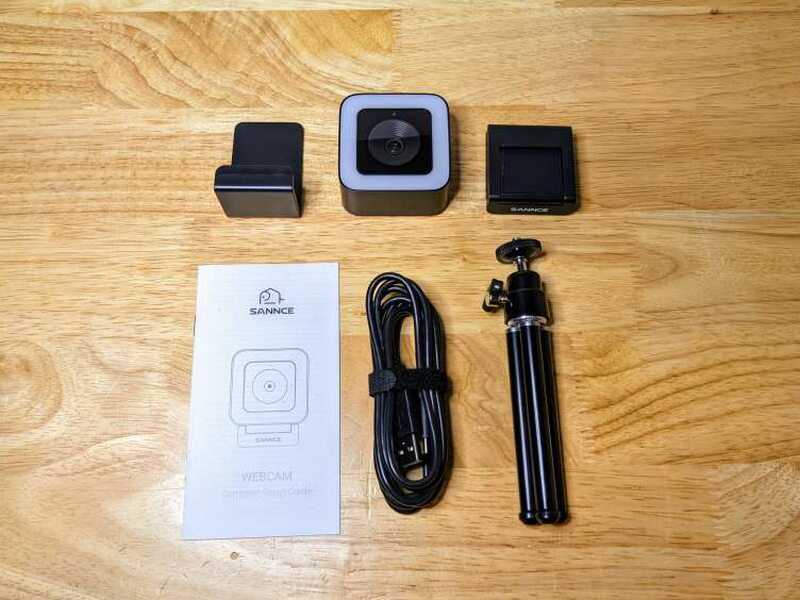The full box contents include the webcam, base, privacy cover, cable, tripod, and manual.