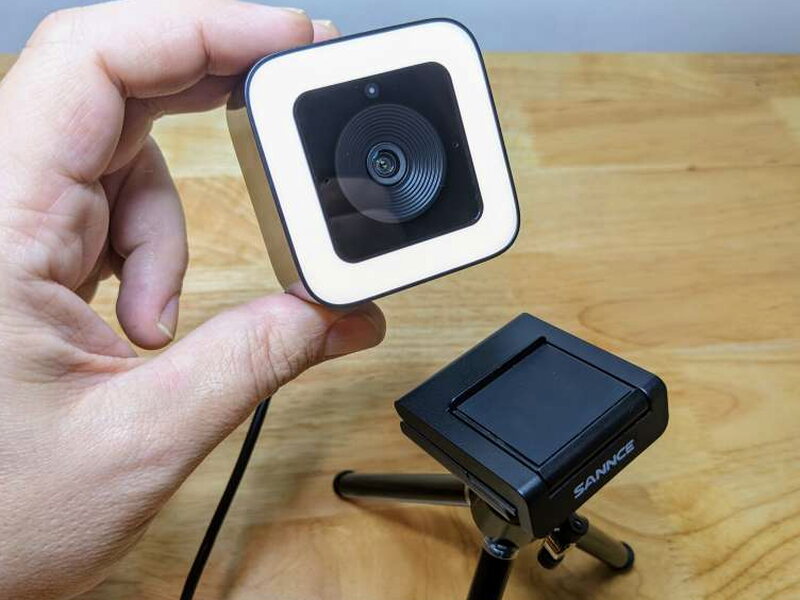 The webcam being lifted from the magnetic base attached to the tripod.