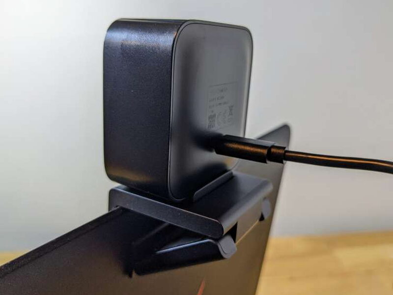A side view of the webcam mounted on a display with the cable attached.