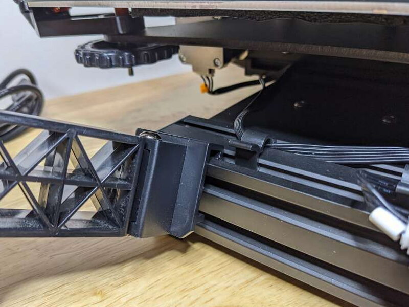The filament holder hooks into the side grooves of the printer base.