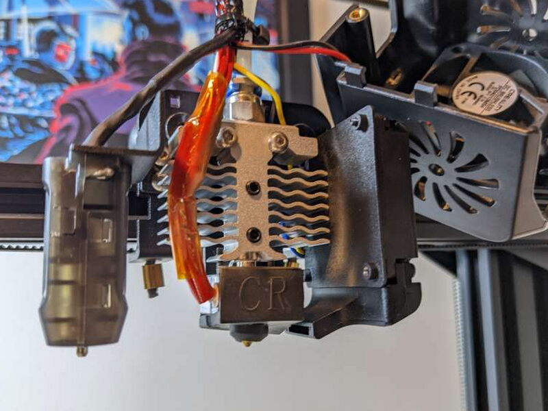 The hotend assembly with the cover removed, exposing the heat sink and wiring.