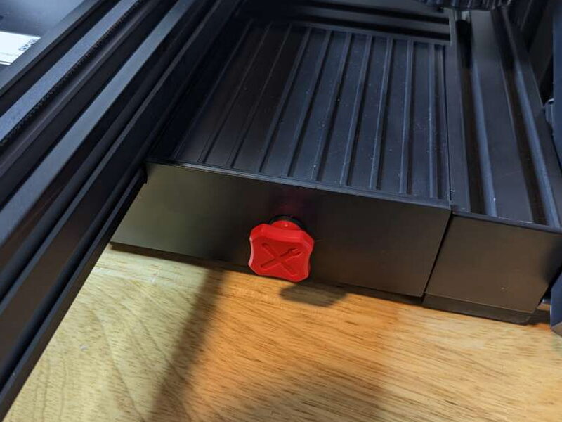 The matching red Y axis belt tensioner knob sits at the front of the base.