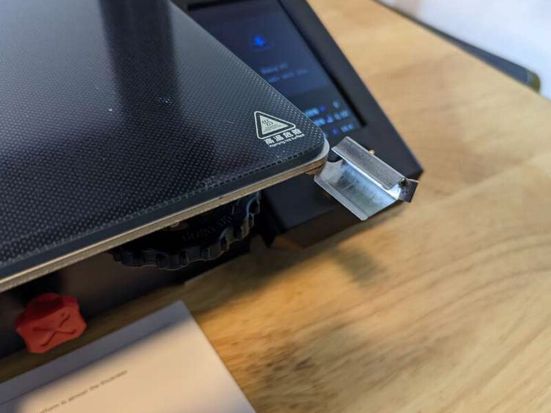 Metal clips hold the removable glass build plate in place.