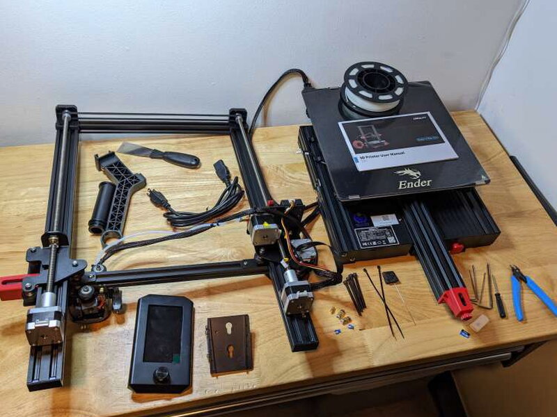 The main printer parts, control screen, tools, filament holder, and accessories laid out after unboxing.