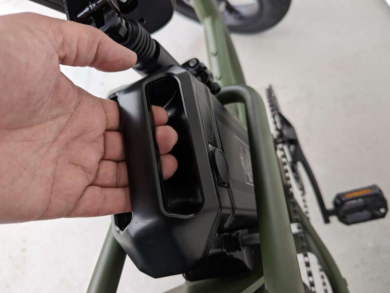 The battery being lifted out of the frame by its integrated handle.