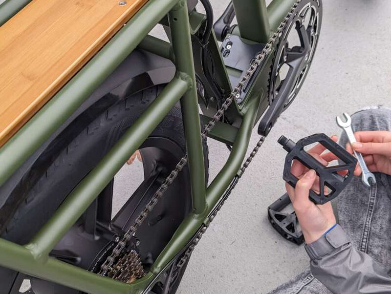 Installing a pedal onto the crank with the included wrench nearby.