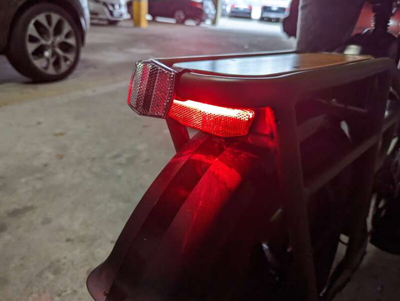 The rear red light glowing on the back of the cargo rack.