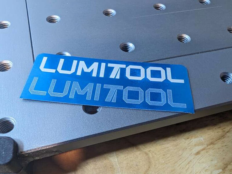 The finished logo, catching the light on brushed aluminum.