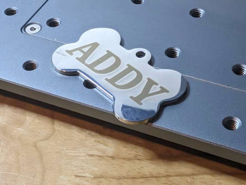 The finished tag: a bone-shaped blank with Addy’s name engraved in clean, deep lettering.