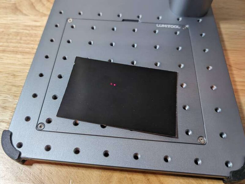The dot, faint, landing on a piece of the black test material.