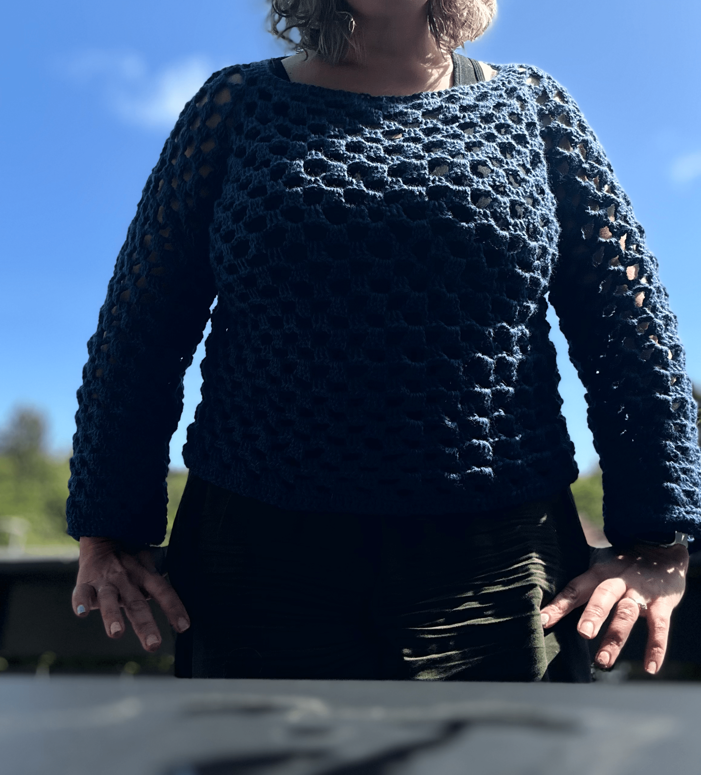 picture of a torso with a dark blue crochet sweater.